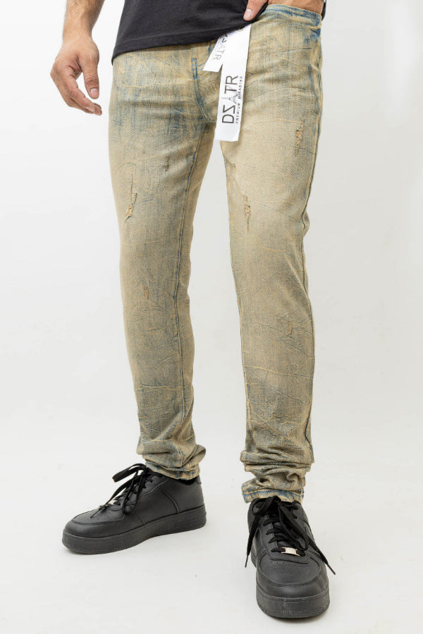 Person wearing distressed beige jeans with a visible brand label on a white background
