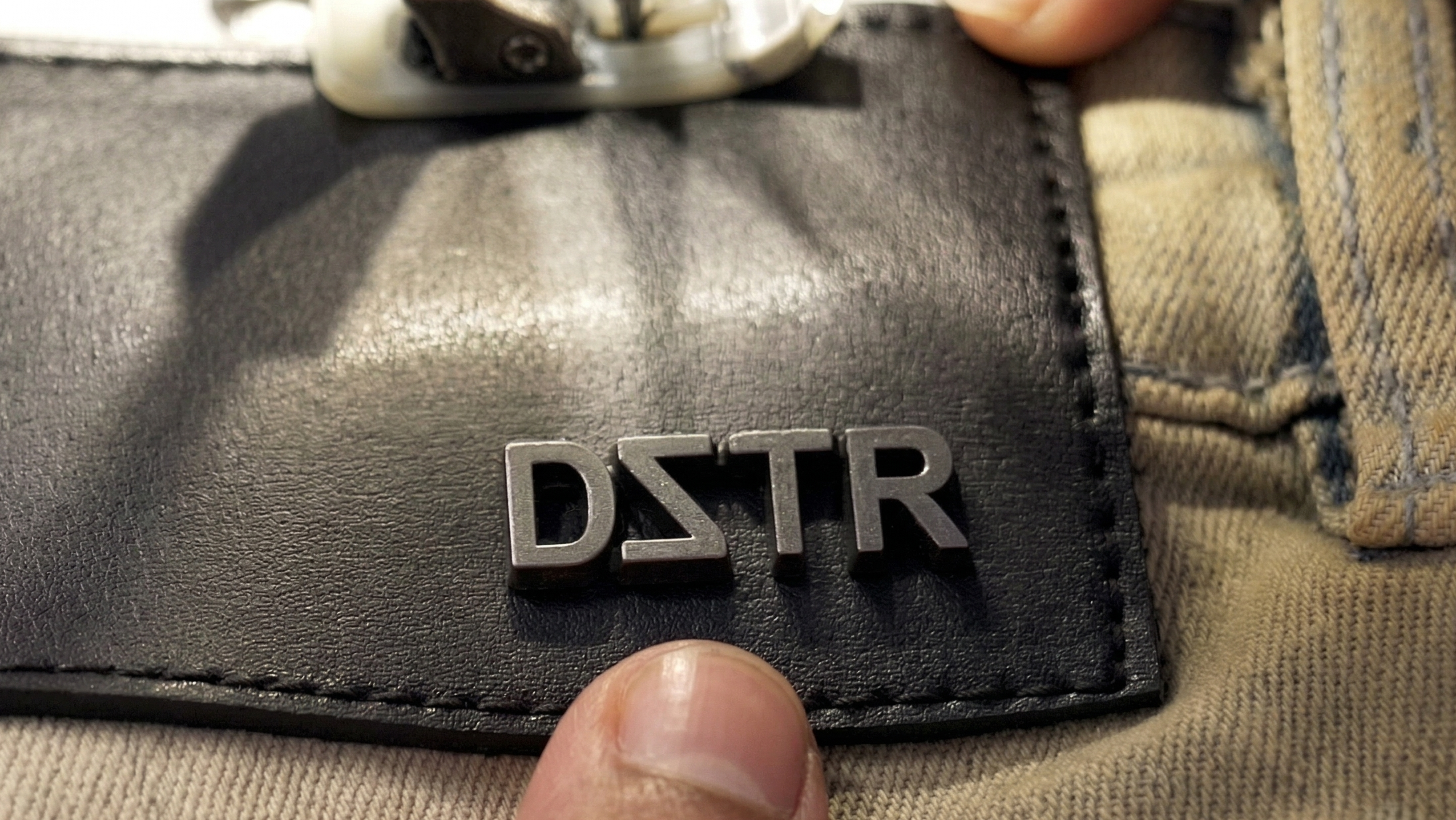 Black patch with 'DSTR' logo on a textured surface